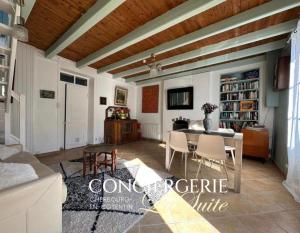 a living room with a table and chairs at Le Nid du Matelot in Saint-Vaast-la-Hougue
