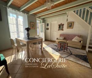 a living room with a table and a couch at Le Nid du Matelot in Saint-Vaast-la-Hougue