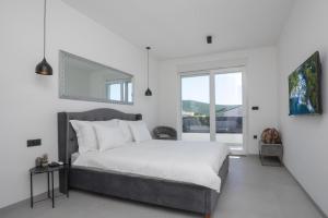 a white bedroom with a bed and a window at Villa della Rode in Lozovac +83 photos