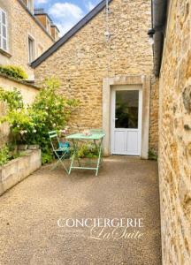 a table and a chair in front of a building at Le Nid du Matelot in Saint-Vaast-la-Hougue