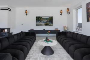 a living room with black couches and a table at Villa della Rode in Lozovac