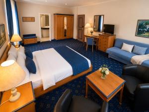 a hotel room with a bed and a couch at Hotel zum Felsenkeller Oybin in Oybin