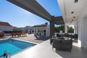 a patio with a swimming pool and patio furniture at Villa della Rode in Lozovac