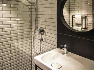 a bathroom with a sink and a mirror at ibis Wels in Wels +72 photos