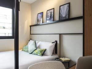 a bedroom with a white bed with two pillows at ibis Brussels Centre Chatelain in Brussels