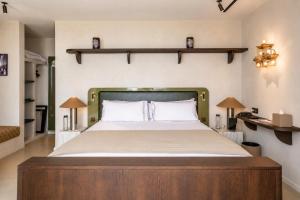 a bedroom with a large bed with a wooden headboard at ROSEMARY hôtel in Bastia