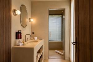 a white bathroom with a sink and a mirror at ROSEMARY hôtel in Bastia +27 photos
