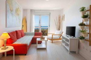 a living room with a red couch and a television at Numancia 1-1A in Las Palmas de Gran Canaria