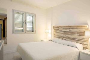 a white bedroom with a bed and two windows at Numancia 1-1A in Las Palmas de Gran Canaria