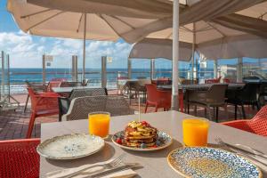 a table with plates of breakfast food and orange juice at Numancia 1-1A in Las Palmas de Gran Canaria