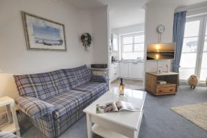 a living room with a couch and a table at Syltglück in Westerland