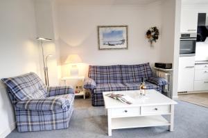 a living room with two chairs and a coffee table at Syltglück in Westerland +22 photos