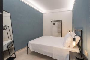 a bedroom with a white bed and a shower at Parmenide Family Apartment in Ascea