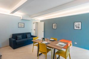 a dining room with a table and chairs and a couch at Parmenide Family Apartment in Ascea