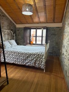a bedroom with a bed in a stone wall at Casa gallega Cedeira in Montojo