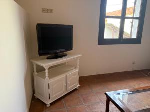 a television on a white stand in a room at Casa gallega Cedeira in Montojo