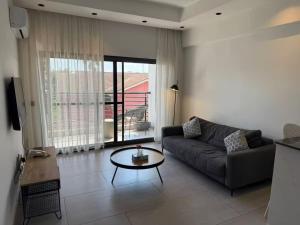 a living room with a couch and a table at QUATTRO-Sky Suites in Accra