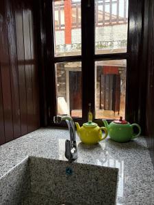 a sink with two teapots on a counter next to a window at Casa gallega Cedeira in Montojo