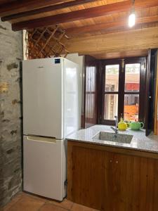 a kitchen with a white refrigerator and a sink at Casa gallega Cedeira in Montojo +16 photos