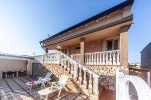 a balcony of a house with white chairs and a table at Dream Houses in Marina di Palma
