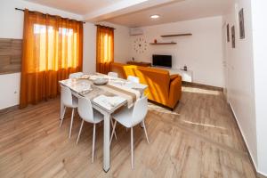 a dining room with a table and white chairs at Dream Houses in Marina di Palma