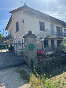 a house with a gate and a fence with flowers at Le Coccole Del Trasimeno in Tuoro sul Trasimeno