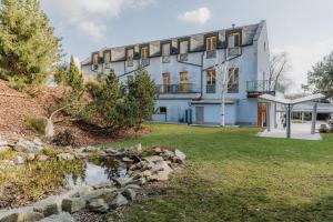 a building with a pond in front of it at Hotel U Pramenu in Pilsen