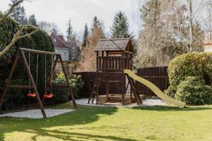 a playground with a slide and a swing at Hotel U Pramenu in Pilsen