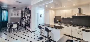 a kitchen with white cabinets and a black and white floor at Dream Houses in Marina di Palma