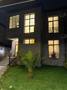 a house with a palm tree in the front yard at Casa de prime in Baku