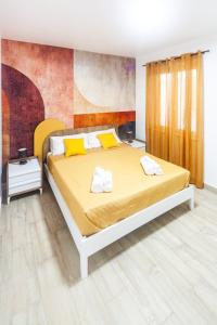 a bedroom with a bed with yellow sheets and yellow pillows at Dream Houses in Marina di Palma