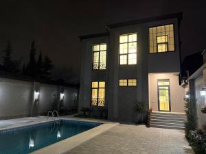 a house with a swimming pool at night at Casa de prime in Baku