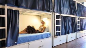 a woman sitting on a bed in a hostel bunk room at Onefam Clerigos in Porto +25 photos
