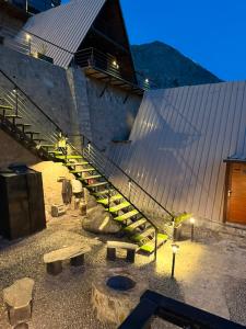 a set of stairs next to a building with benches at Gumaan Resort in Skardu