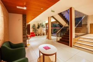 a living room with a green chair and a table at HOTEL GANGa in Mūvattupula