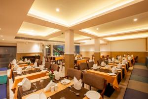 a dining room with tables and chairs in a room at HOTEL GANGa in Mūvattupula