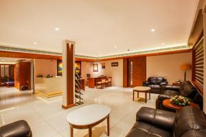 a living room with leather furniture and a dining room at HOTEL GANGa in Mūvattupula +9 photos