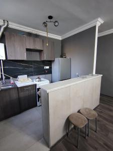 a kitchen with a counter and a stool and a refrigerator at Guest House in Garni