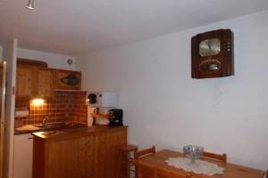 a kitchen with a table and a refrigerator and a counter at Studio with mountain view in Barcelonnette in Barcelonnette