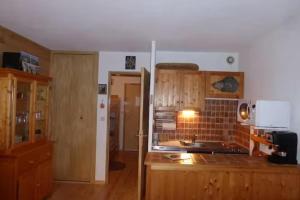 a kitchen with wooden cabinets and a counter top at Studio with mountain view in Barcelonnette in Barcelonnette