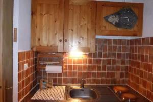 a kitchen with a sink and wooden cabinets at Studio with mountain view in Barcelonnette in Barcelonnette +3 photos