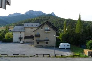a building with a car parked in a parking lot at Studio with mountain view in Barcelonnette in Barcelonnette