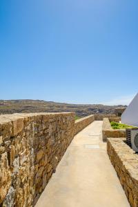 a stone wall next to a road at Nevo Mykonos in Mikonos +12 photos