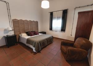 a bedroom with a bed and a chair at Bodega Andrés Iniesta con visita y cata in Fuentealbilla
