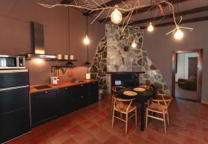 a kitchen with a table and a stone fireplace at Bodega Andrés Iniesta con visita y cata in Fuentealbilla