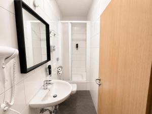 a white bathroom with a sink and a mirror at Nivara Hotel in Hamburg +27 photos