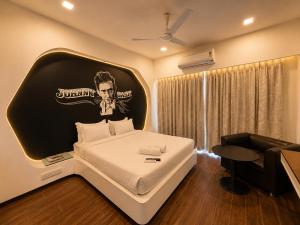 a bedroom with a large bed with a black and white headboard at Cosset - A Boutique Hotel in Lonavala