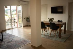 a dining room and living room with a table and chairs at Apartmani ELEGANCE Tuzla in Tuzla