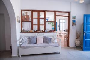a room with a white bench with pillows on it at Avra Pension in Ios Chora