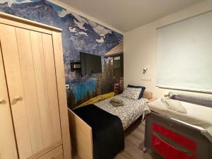 ein kleines Schlafzimmer mit zwei Betten und einem Wandgemälde in der Unterkunft Blue Mountains in Wavre